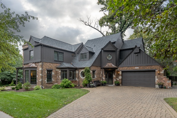 Exterior photograph of a recently remodeled home with brick walls and black siding