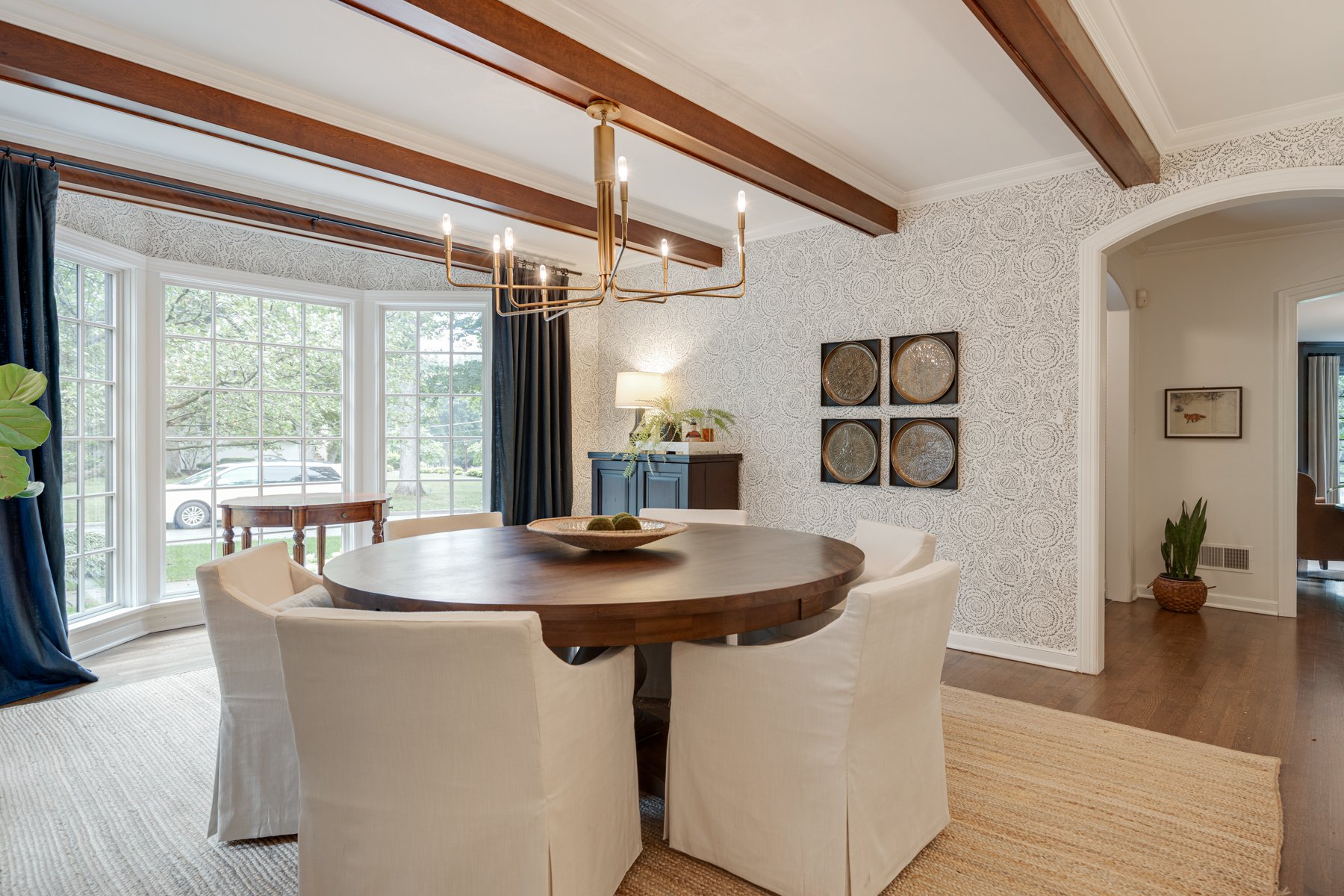 High-end, luxury, contemporary dining room remodel with exposed beams and a full wall height floor to ceiling window pane
