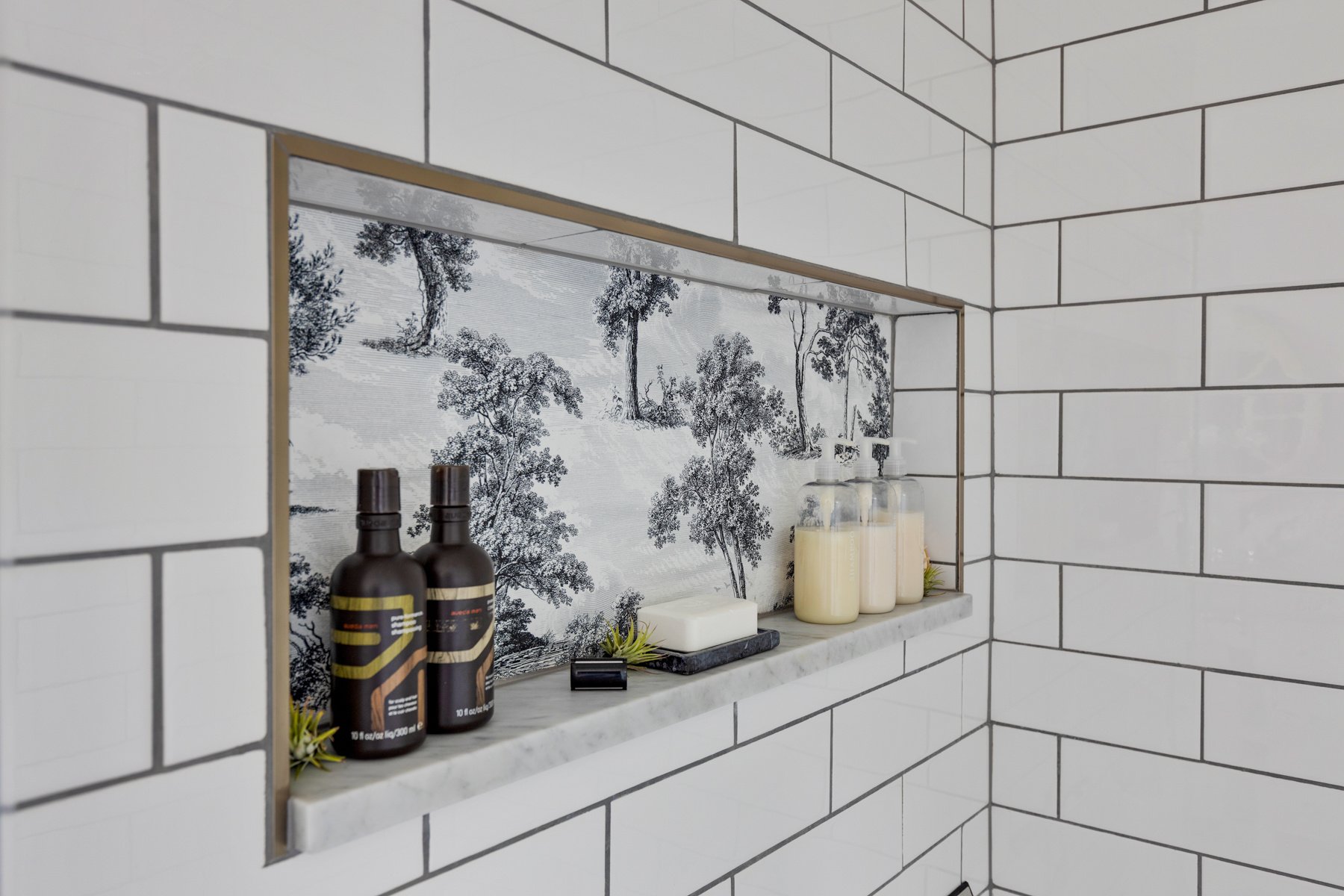A unique niche adds an elegant look to white shower tile