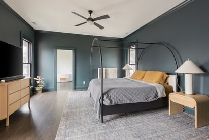 Master bedroom with a king sized bed that is surrounded by an arch shaped frame