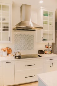 Kitchen range with an overhead mounted exhaust fan
