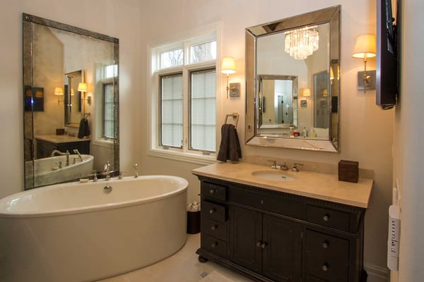 Luxurious bathroom with warm white lighting, large mirrors, and a single vanity bathroom counter