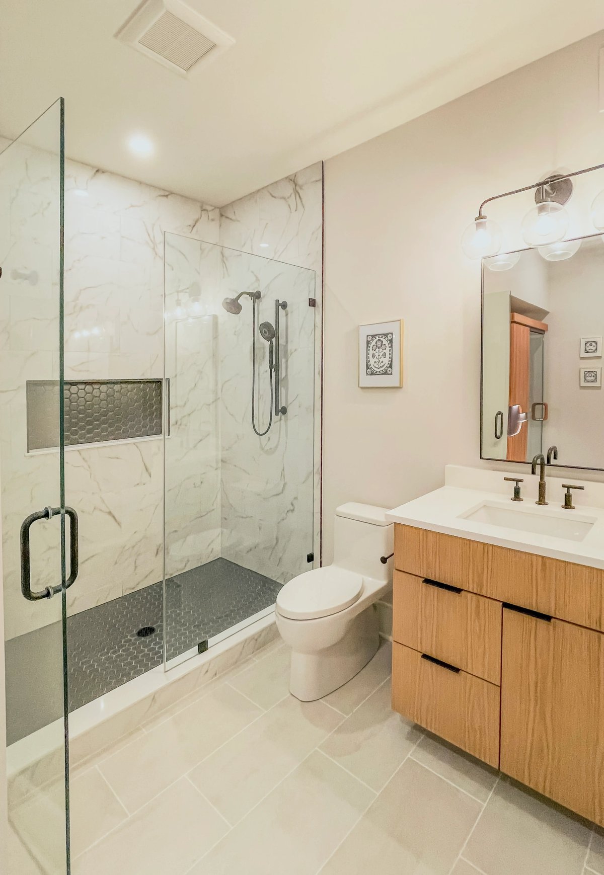 Luxury bathrom with shower enclosed, glass panel door opened , wooden cabinet beside a water closet
