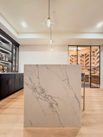 A marbled, waterfalled countertop for a basement wet bar