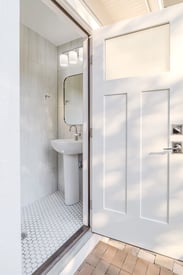 A powder room with an access point from the outside, making it a perfect mudroom for the backyard pool