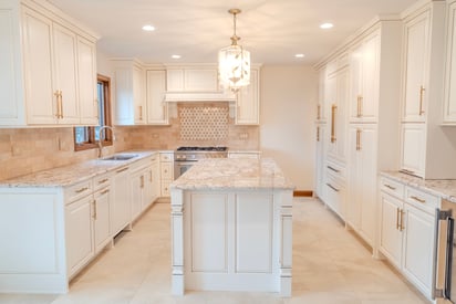 Kitchen remodeling project with white trim and white cabinetry all throughout the space, as well as soft white lighting filling the space