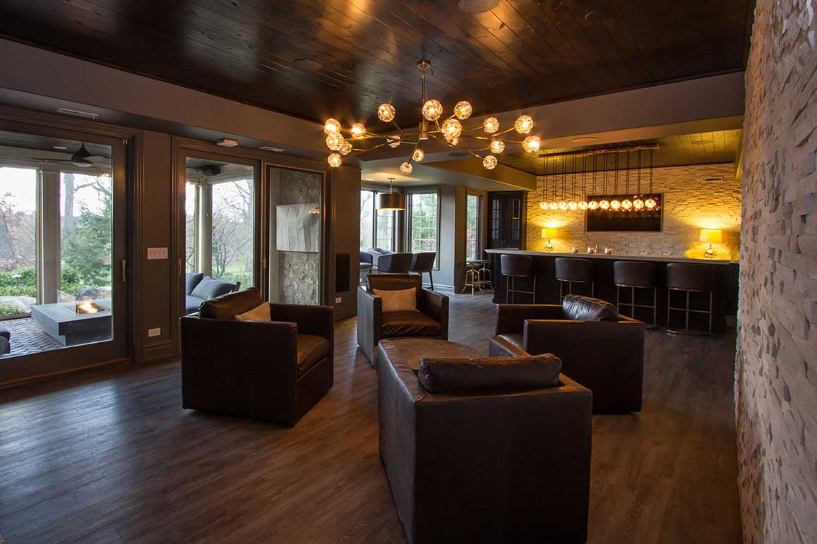 Moody-themed basement turned into an entertainment area with floor-to-ceiling doors and windows for natural lights