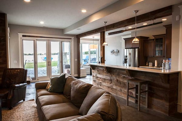 Warm and inviting basement with a rustic farmhouse wet bar design featuring wood accents