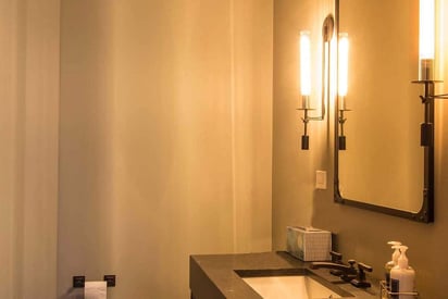Guest bathroom with two LED candle lights next to a single vanity mirror