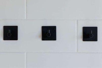 3 shower jets and handles mounted on the while tile wall