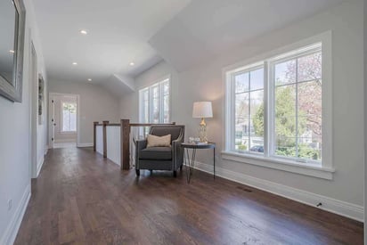 Second story landing with hardwood floors and a small reading nook at the top of the stairs