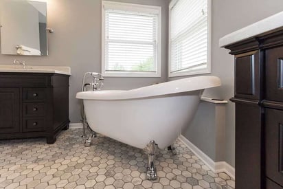 Claw footed bath tub with two windows on either side of the wall