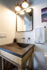 Single bathroom vanity with two lamps above the mirror for plenty of light