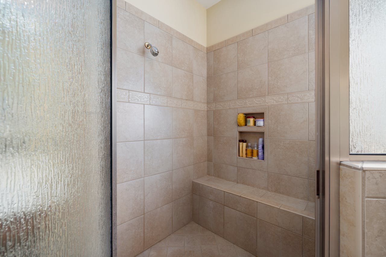A thin-edged bathroom bench installed below a shower recess 