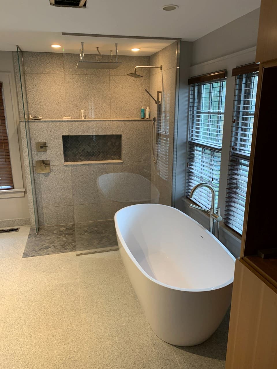 Zero entry walk-in shower with rain showerhead and separate tub