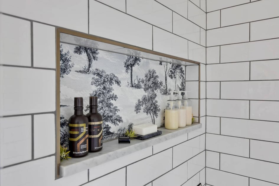 Recessed shower niche with background tile that has a hand-painted tropical motif