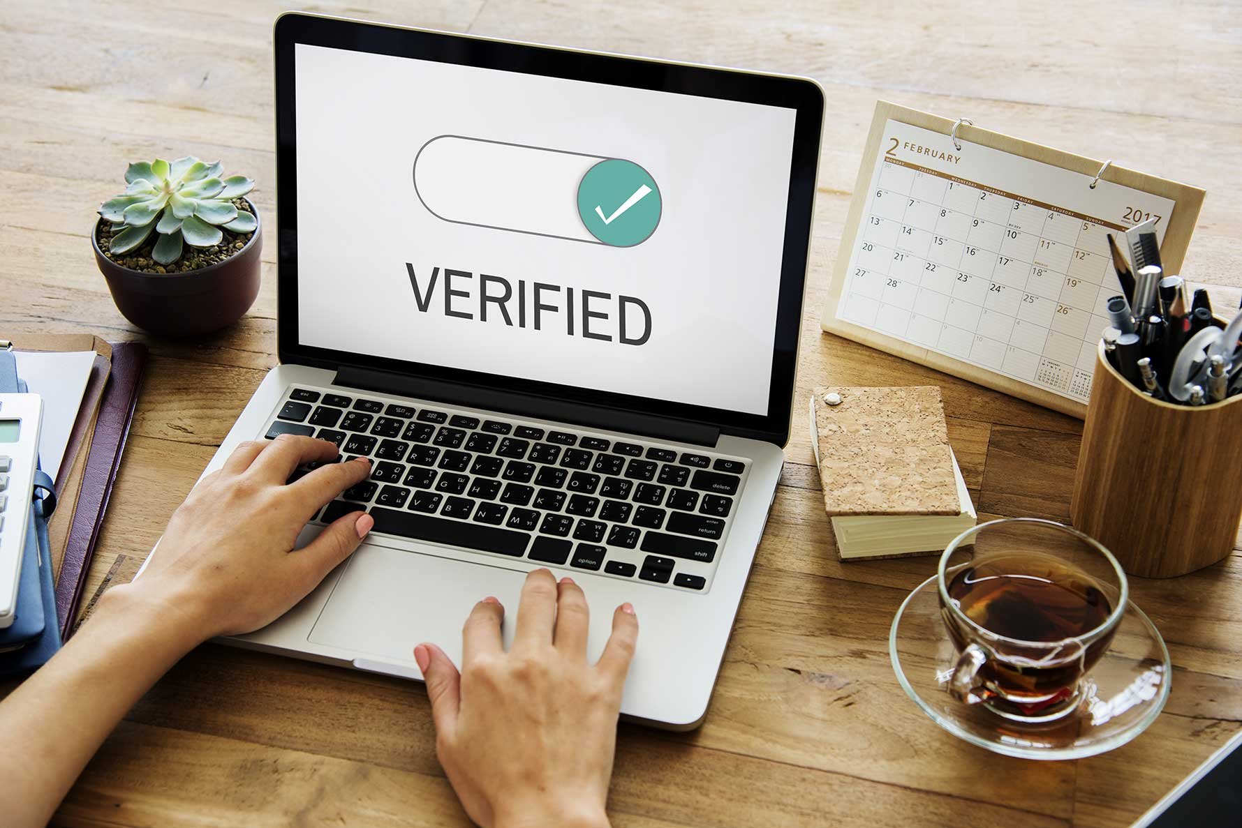 Laptop on table with screen that says verified