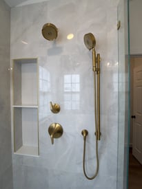 Close up of gold shower appliances and fixtures in a shower