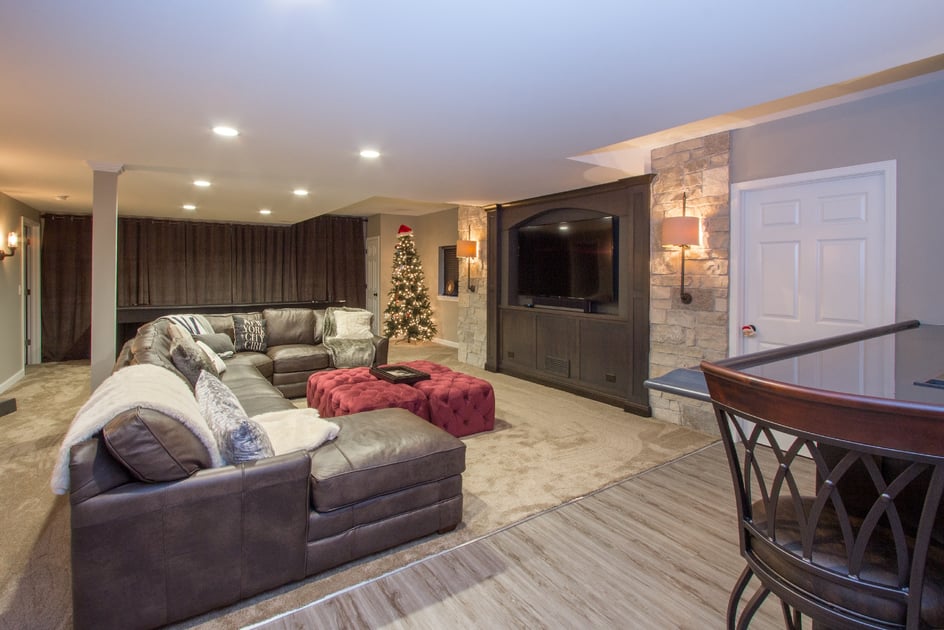 Remodeled basement with U-shaped couch and media area