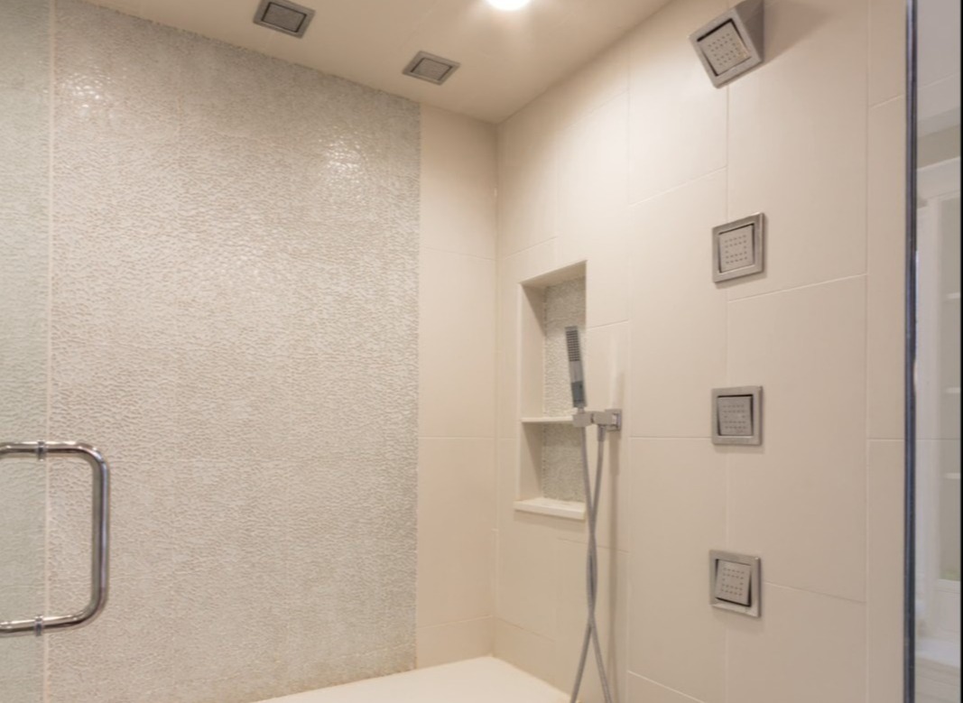 Bathroom with corian backsplash and shower niche made with tiles