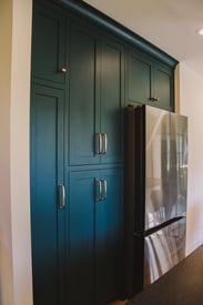 Floor to ceiling kitchen cabinets surrounding the fridge for extra storage space