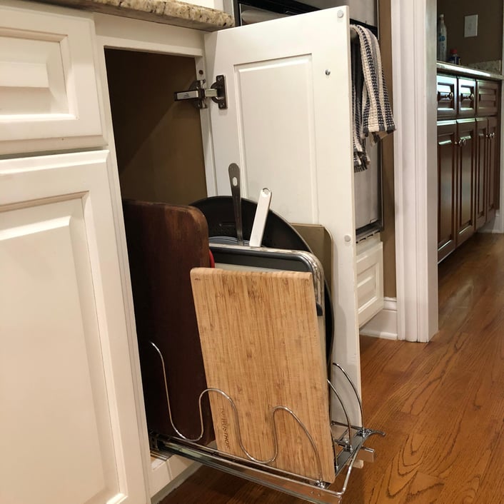 A retro-fitted, narrow cupboard pull out drawer rack for cookie sheets and cutting boards