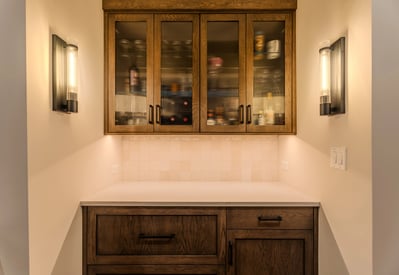 Butler's pantry with overhead cabinets or storage, two wall sconces for lighting, and a small countertop
