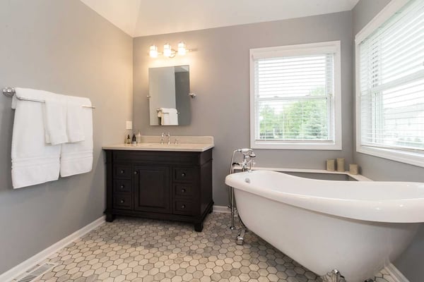 Guest bathroom oasis with single vanity and a stand alone claw footed bathtub