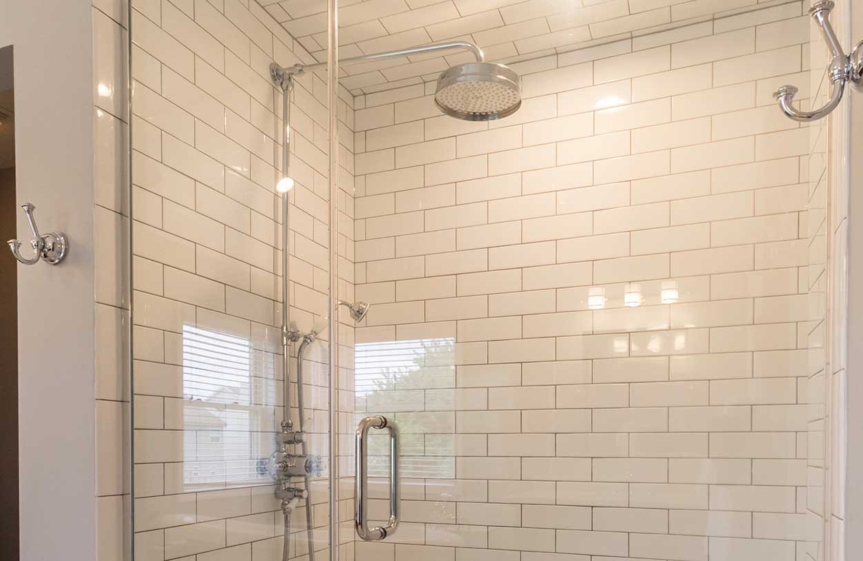 A tiled shower area with round rain head and ensuite glasses | Tile For Shower Niche