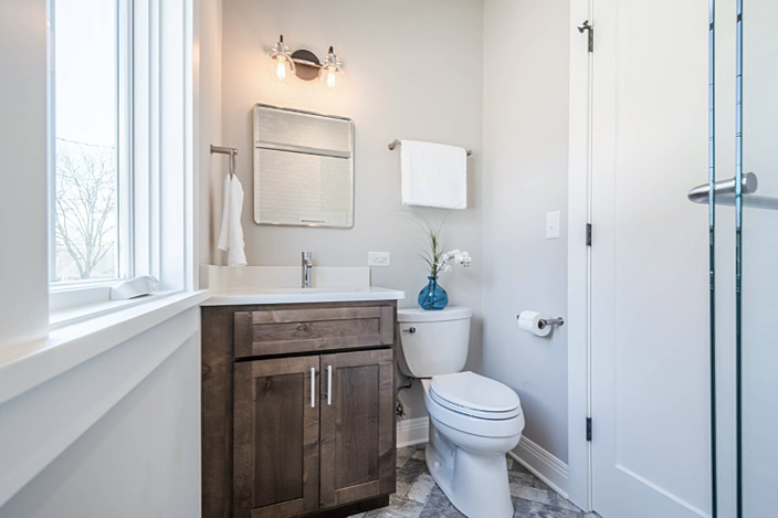 small-powder-bathroom-with-single-sink-wood-vanity-and-toilet