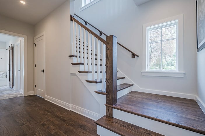 Wood stairs with stained wood treads , banisters and rails with white risers