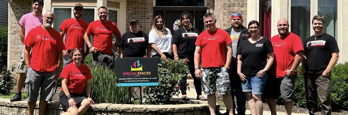 Hogan Design and Construction, home remodeling team, pose together infront of a brick home front door.