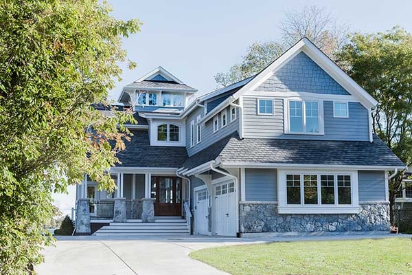 Pastel blue 3 story home with a two car garage and beautiful white trim