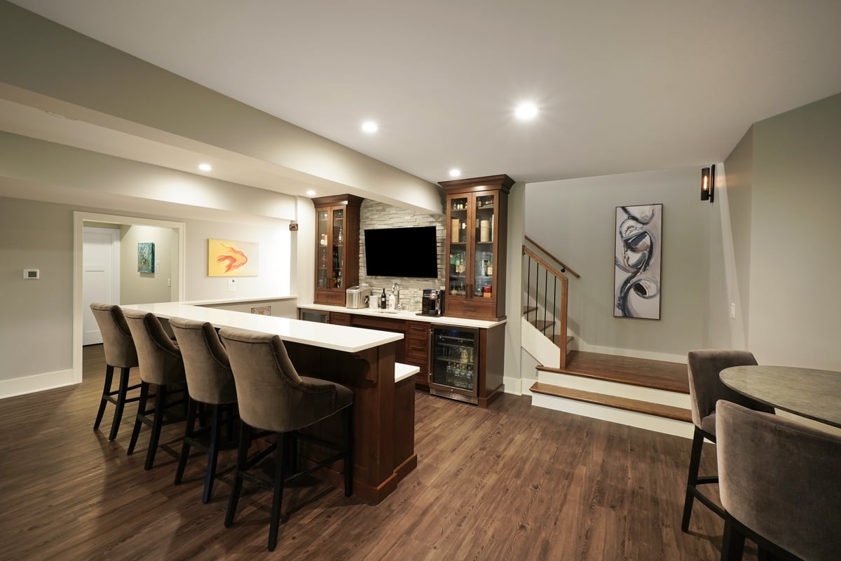 House bar with bar stools and a staircase leading upstair