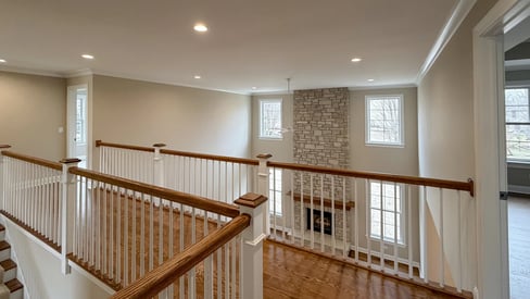Second story landing with white railings and banister, overlooking the family room
