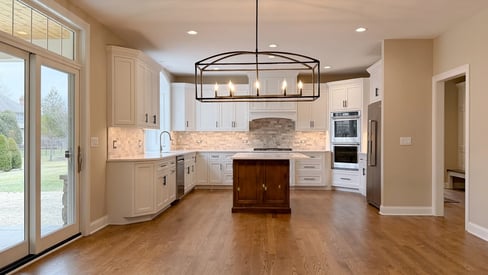 An empty dining room post home remodel with the elegant kitchen in the background