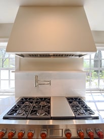 Kitchen stove with exhaust hood mounted overhead