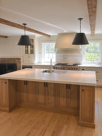 Kitchen Island with two pendant lights and cabinets mounted underneath seating area