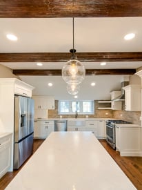 Pendant lights suspended over a white kitchen island countertop