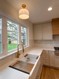 A close up angle of a kitchen island with a sink, drying rack, and prep station