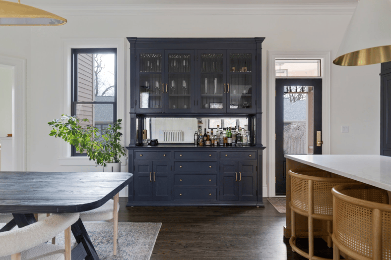Kitchen dry bar created from a repurposed old hutch, painted navy blue with an antiqued mirror added to the back