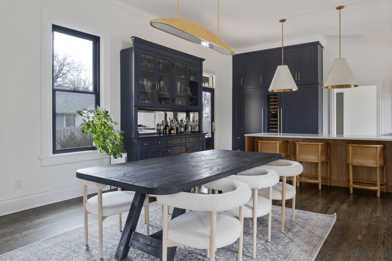 Navy blue and white, open floor plan kitchen and dining space with gold accents and a repurposed old hutch