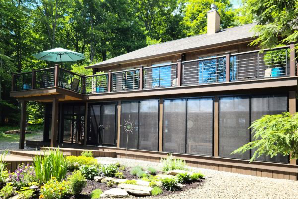 Screened in porch lower level with deck above with horizontal metal spindles and Trex posts