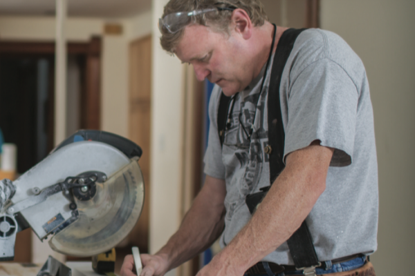 Carpenter using saw with dust mitigation system