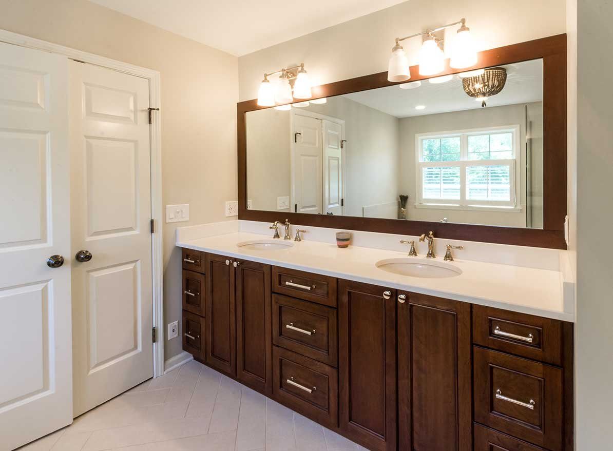 A guest bathroom with a double vanity and large mirror for catering to multiple guests